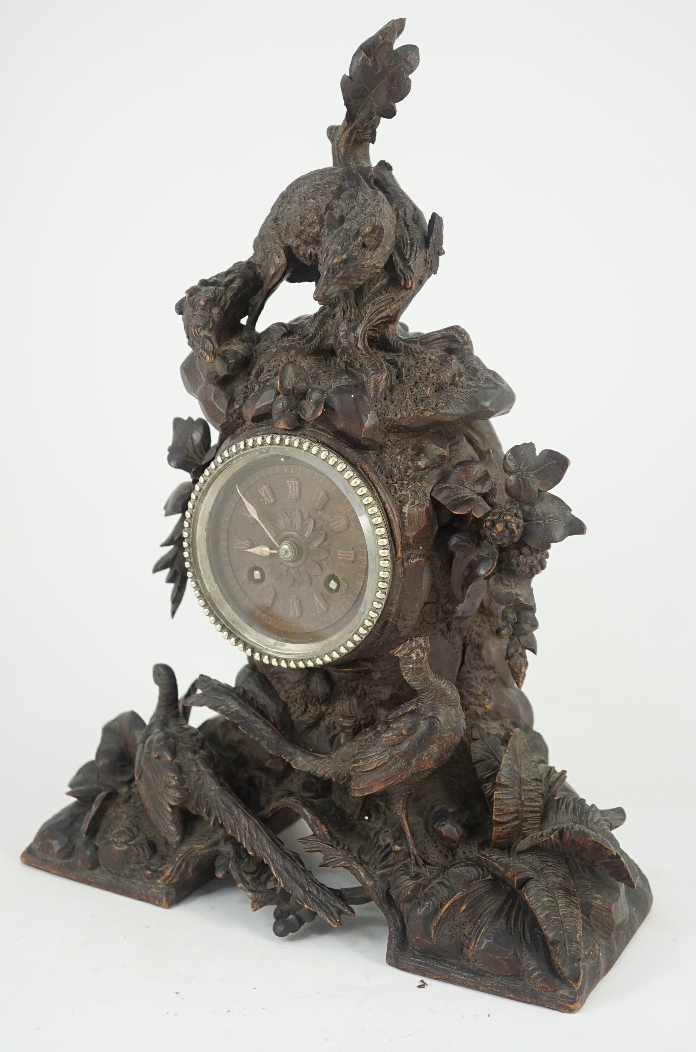 A 19th century Black Forest carved wood mantel timepiece, 30cm wide, 38cm high